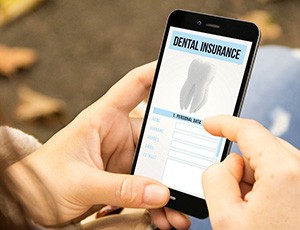 A woman looking at a dental insurance app on her phone