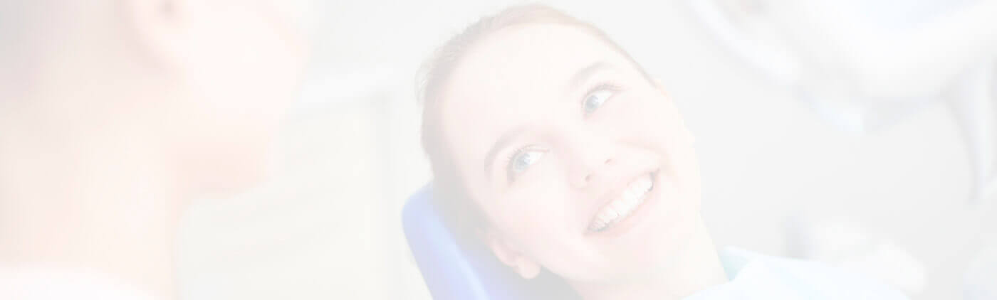 Lady lying on dental chair looking up smiling