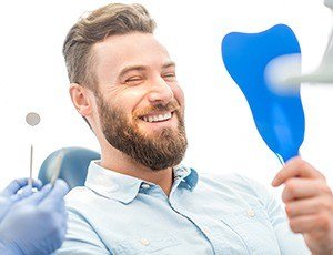 Man looking at smile in mirror