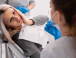 Lady looks to dentist with oral pain.