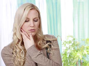 Woman with a toothache in Fayetteville holding her cheek