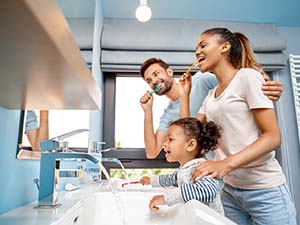 Family brushing teeth together to prevent dental emergencies in Fayetteville