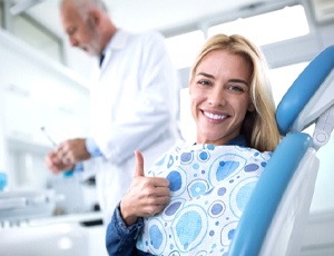 woman giving thumbs up before getting tooth extractions in Fayetteville