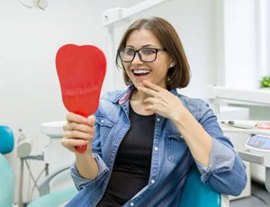 A woman smiling at herself in a mirror