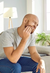 man experiencing dental emergency 