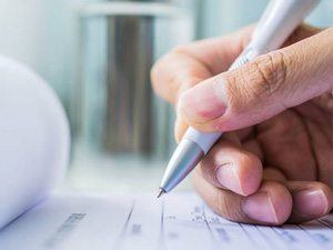 Hand holding pen to fill out patient forms