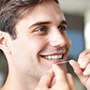 Man flossing teeth happily