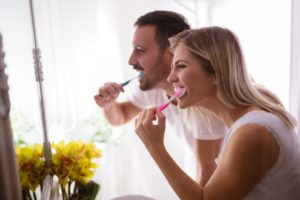 Man and woman brushing teeth