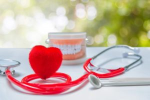 Heart shape and model teeth next to Fayetteville dentist stethoscope