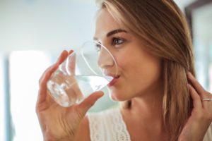 woman drinking water to prevent dental emergencies