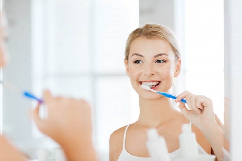 Woman Brushing Teeth in Bathroom