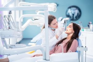 a patient smiling while visiting their dentist 