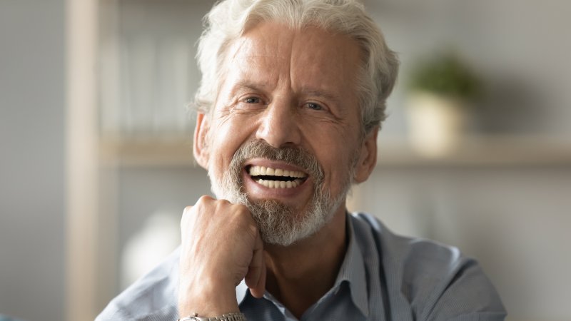 a man smiling while wearing dentures