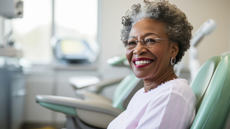 Former denture patient smiling with dental implants